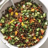 Eine bunte Linsensalat-Mischung mit frischem Gemüse und Kräutern.