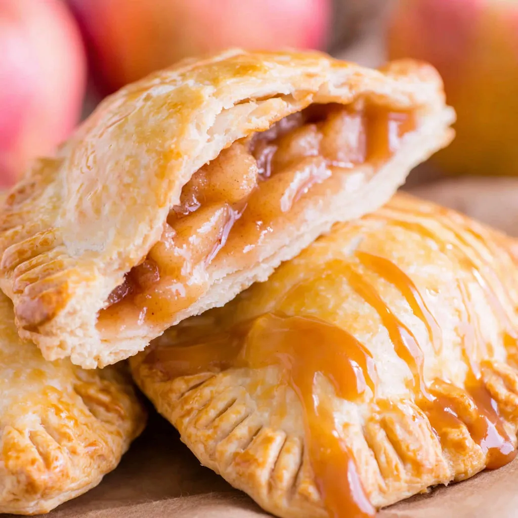 Two caramel apple hand pies on a table.