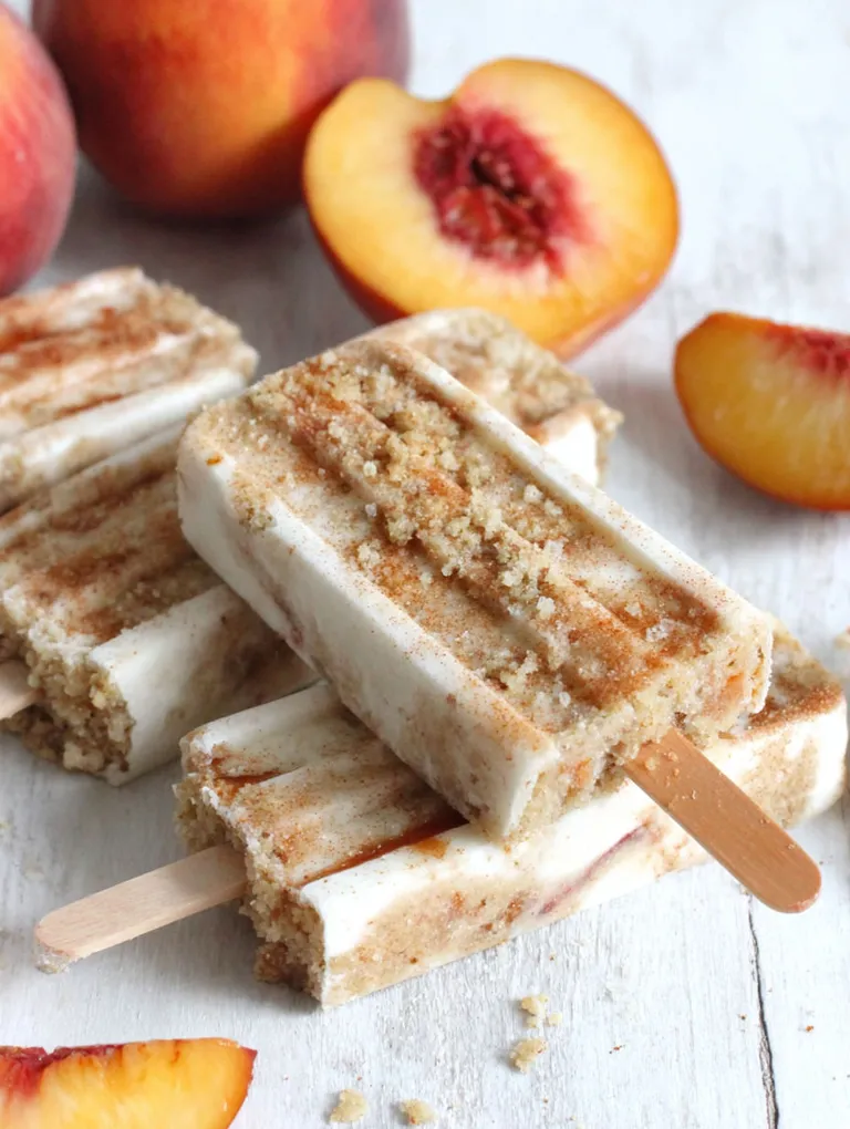 Peach streusel popsicles on a white table.
