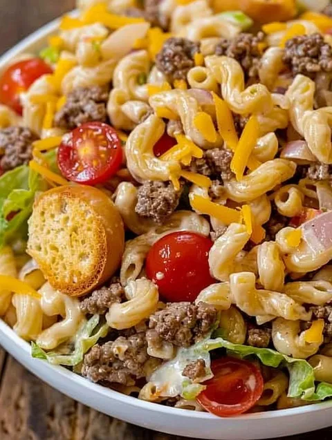 A bowl of pasta salad with tomatoes and cheese.